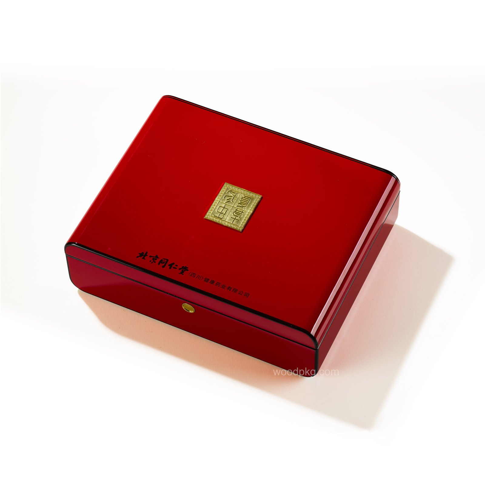 Red high-gloss MDF wooden box with rounded edges, embossed metal logo plaque, hand-painted black trim, and a smooth button clasp