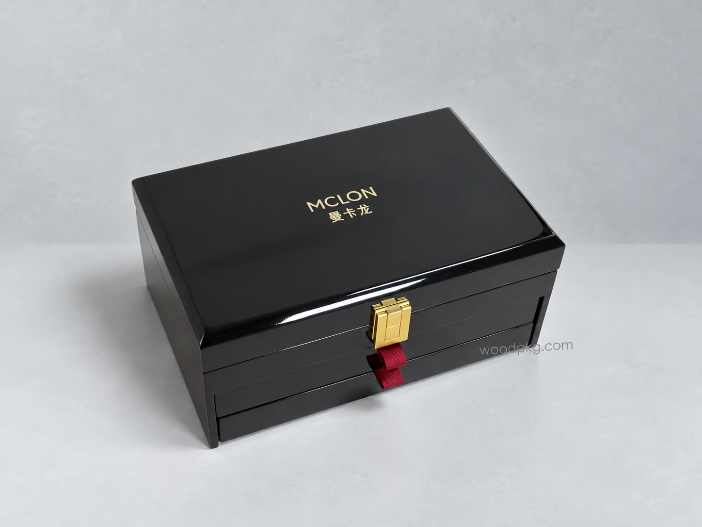 Custom black high-gloss wooden jewelry box with multiple storage layers, a gold-tone clasp, and red ribbon drawer pulls.